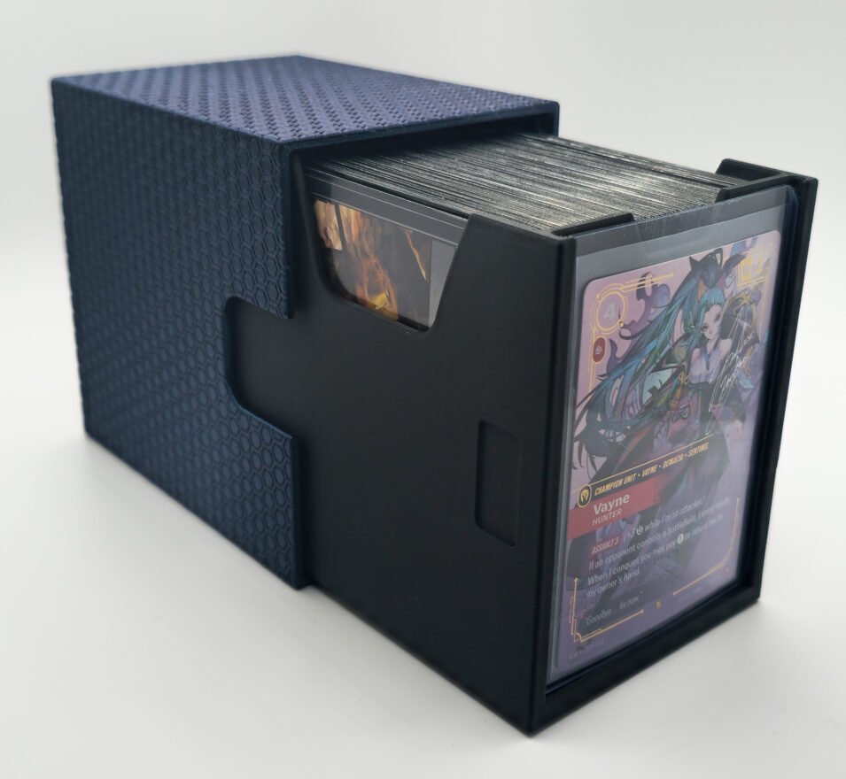 Geöffnete Riftbound-Deckbox von Amzicards in Galaxy Black: Hülle mit Hex-Muster, schwarze Innenbox mit Kartenstapel, vorn ein Toploader mit der Champion-Karte Vayne